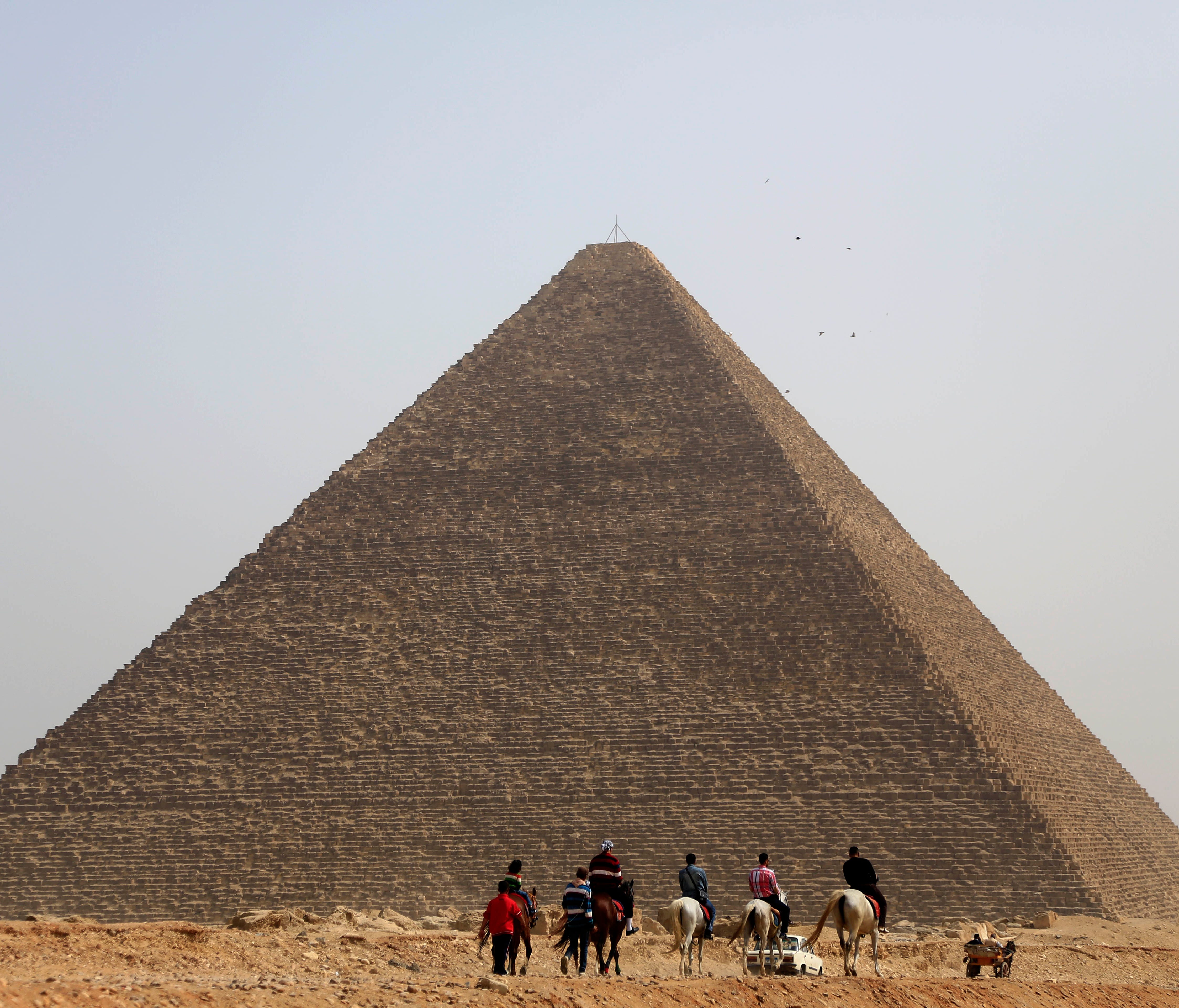 Tourists ride horses at the historical site of the Giza Pyramids in Giza, near Cairo, Egypt, Wednesday, March 5, 2014.