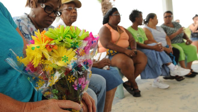 Barbara Grossman holds a bouquet to give to the family of Uvihin "Ace" Horton, who drowned on Sunday, at Cape Charles.