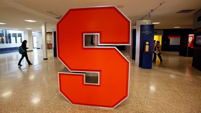 A Syracuse University logo is displayed inside the lobby of the Carmelo K. Anthony Basketball Center.