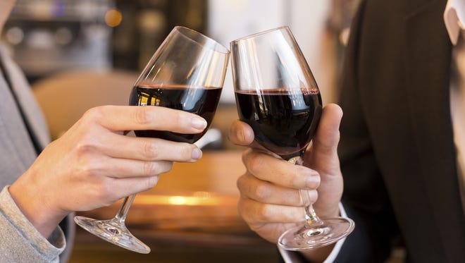 Couple toasting with red wine glasses.