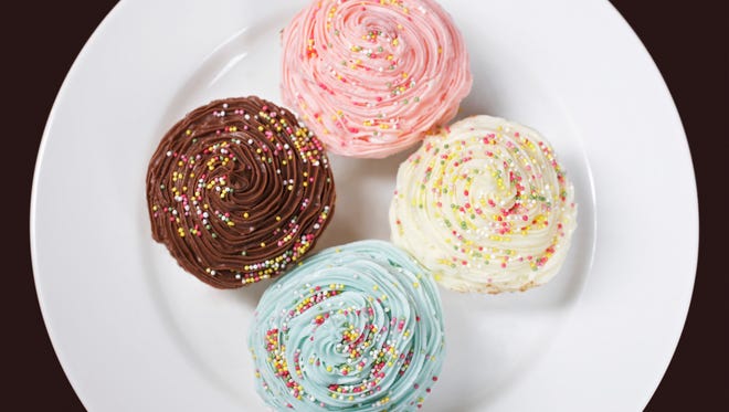 Colourful cupcakes on plate, view from above
