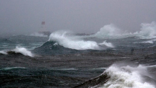 The Upper Harbor Breakwall Lighthouse takes a beating from Lake Superior with thirty plus mph winds on Tuesday Nov. 11, 2014 in Marquette, Mich.