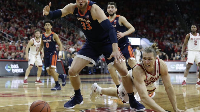 Virginia's Jack Salt, left, and North Carolina State's Wyatt Walker reach for a loose ball during the first half Tuesday. No. 3 Virginia won 66-65 in overtime.