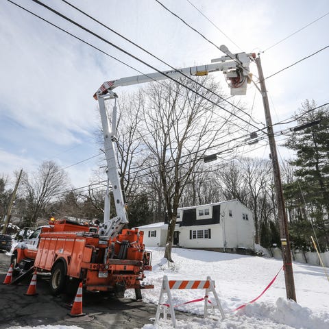 An Orange and Rockland utility worker cuts the pow