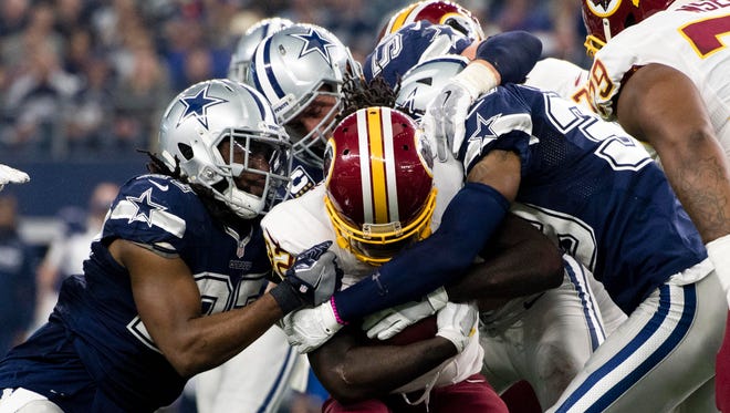 Washington Redskins running back Rob Kelley (32) is gang tackled by the Dallas Cowboys during the game at AT&T Stadium. The Cowboys defeat the Redskins 31-26.