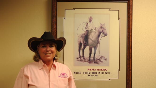 Reno Rodeo Foundation Executive Director Clara Andriola poses in front of a Reno Rodeo poster at the Foundation offices.