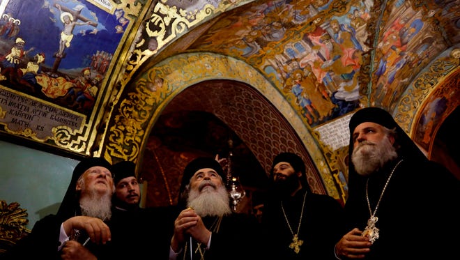 Greek Orthodox Patriarch of Jerusalem Theophilos III, second from left, and Ecumenical Patriarch of Constantinople Bartholomew, I, left, look at the painting of the Golgotha at the Church of the Holy Sepulchre in Jerusalem's Old City on Dec. 5, 2017.