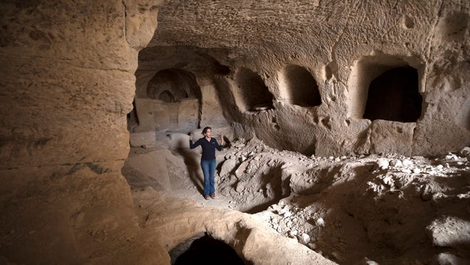 An Israel Antiquities Authority employee, Michal Haber, shows a cave from the Hasmonean period found next to a 2200-year-old structure from the Hellenistic period, possibly an Idumean palace or temple.