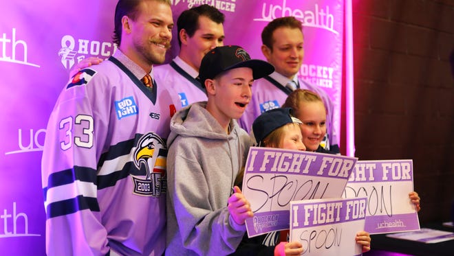 From back left, Eagles goalie Lukas Hafner, defenseman Teigan Zahn and forward Drayson Bowman pose for photos with fans at the team’s Hockey Fights Cancer Weekend game Saturday night. UCHealth and the Eagles teamed up to present the weekend tribute where fans had an opportunity to celebrate their friends and loved ones whose lives have been affected by cancer by filling out “I Fight For” pledge cards. The Eagles defeated the Rapid City Rush 8-1.