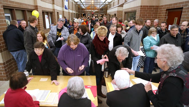 Republican voters register before taking part in caucuses held Feb. 1 at Carroll High School in Carroll, Iowa.