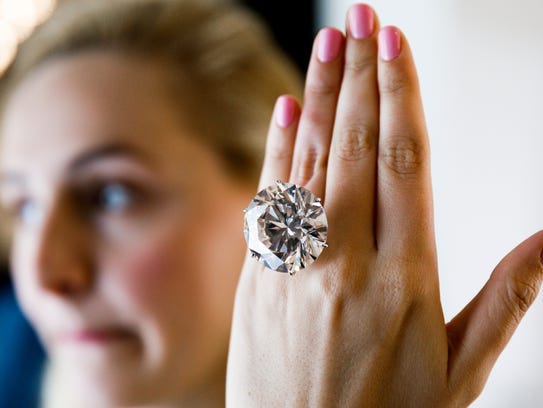 Photo shows a model displaying a 110.92 carat round