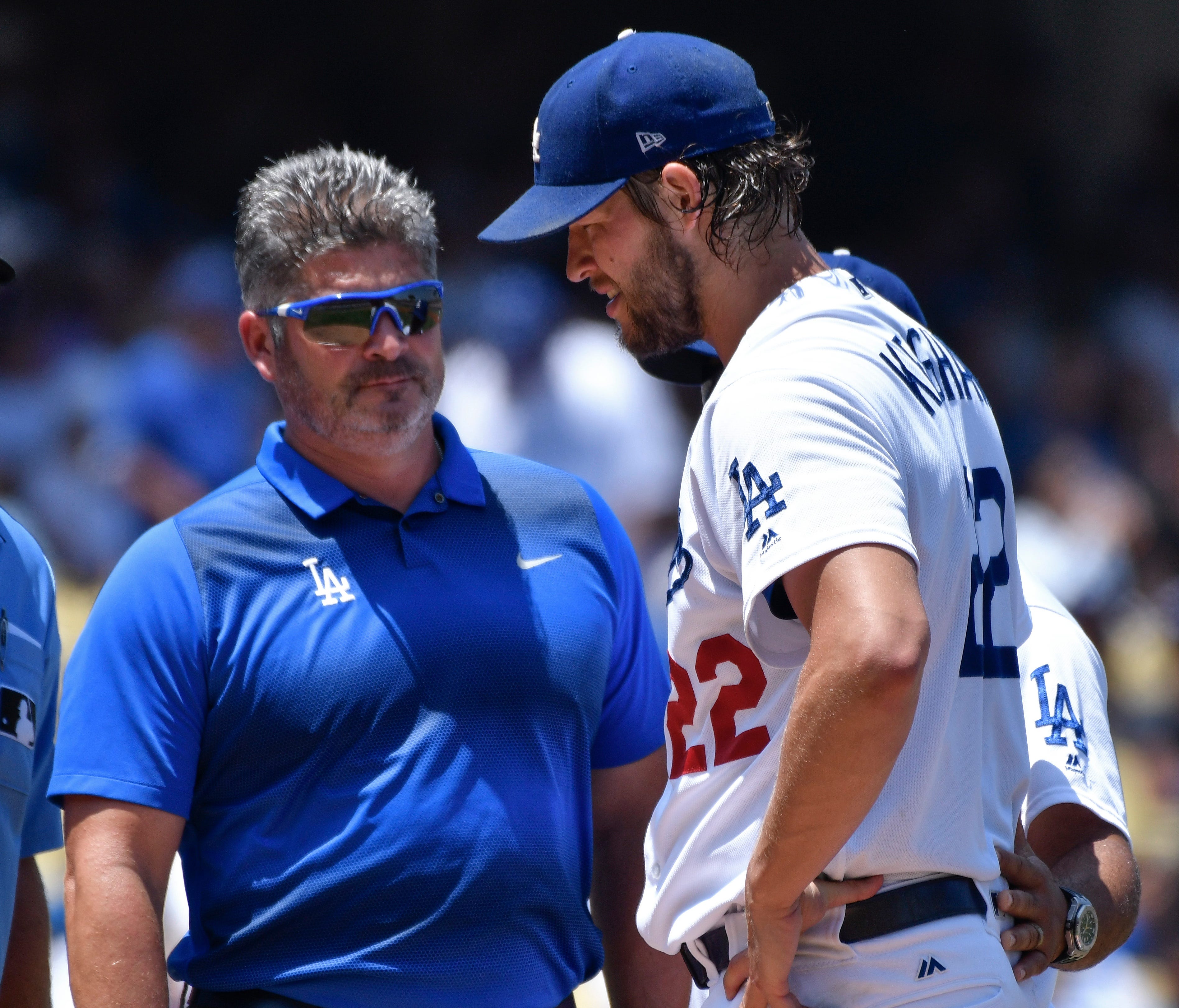 Clayton Kershaw is visited by a trainer during the second inning Sunday.