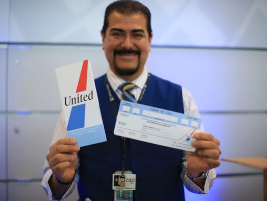 A United Airlines ticket agent poses with special tickets