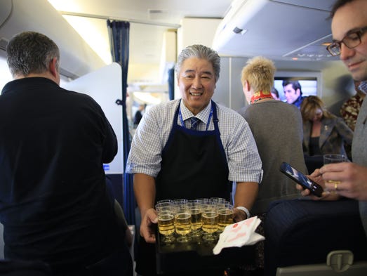 Champagne is served by crew members on the last United