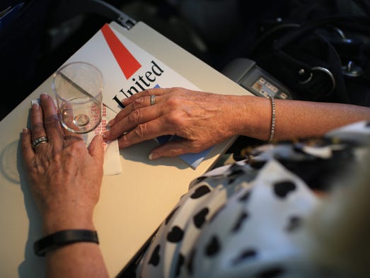 A woman holds an empty champagne glass on her tray
