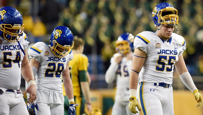 SDSU's Mason Leiseth (55) Chris Balster (28) and Cole Langer (54) walk off the field after their loss to NDSU during the NCAA Division I Football Quarterfinals at the Fargodome on Sat., Dec. 10, 2016.