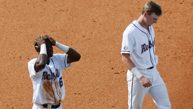 Ole Miss' Errol Robinson, left, and Will Golsan, right, walk off the field after losing to Texas A&M in a Southeastern Conference NCAA college baseball tournament game at the Hoover Met on Saturday.