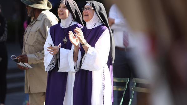 Nuns listen to Pope Francis speech on Fountain Square screen Thursday.