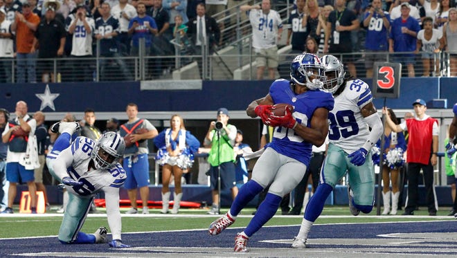 New York Giants wide receiver Victor Cruz (80) catches a touchdown pass in the fourth quarter against Dallas Cowboys cornerback Brandon Carr (39) at AT&T Stadium.  The Giants  won 20-19.