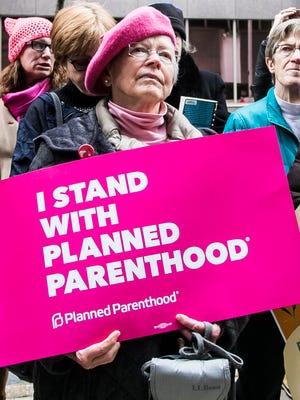 Marjarie Akin, of Boiling Springs stands with a Planned Parenthood sign, during the #TuesdaysWithToomey protest Tuesday, Jan. 31, 2017, outside of the Federal Building in Harrisburg. Amanda J. Cain photo
