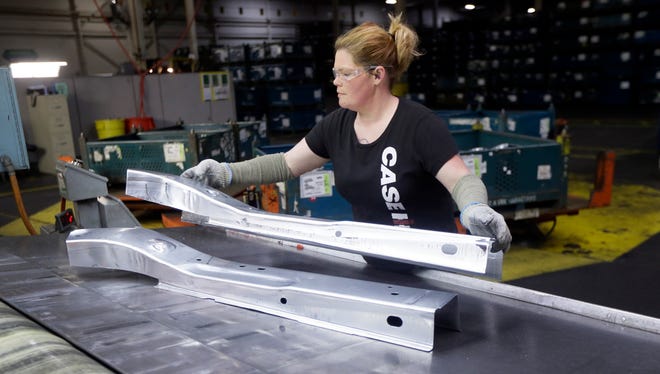 United Auto Workers line worker Crystal McIntyre unloads parts from a stamping machine at the General Motors Pontiac Metal Center in Pontiac, Mich., Thursday, April 30, 2015.