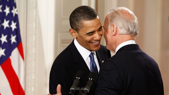 President Barack Obama (L) is embraced by Vice President