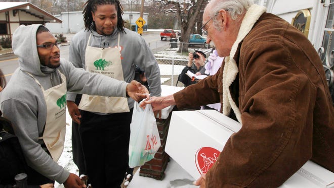 Cincinnati Bengals linebackers Vincent Rey, left, and Vontaze Burfict deliver Meals on Wheels from Senior Services of Northern Kentucky to Roger Bone  at his home in Latonia in 2013.