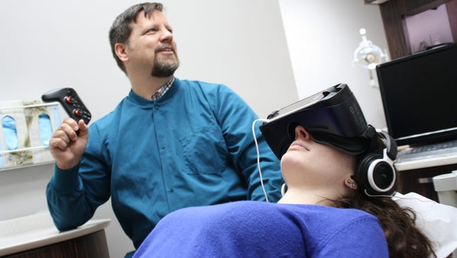 Dr. Matt Palomaki, left, demonstrates the virtual reality device.