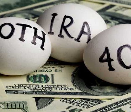Eggs with IRA, 401K, Roth written on them laying on a pile of cash..