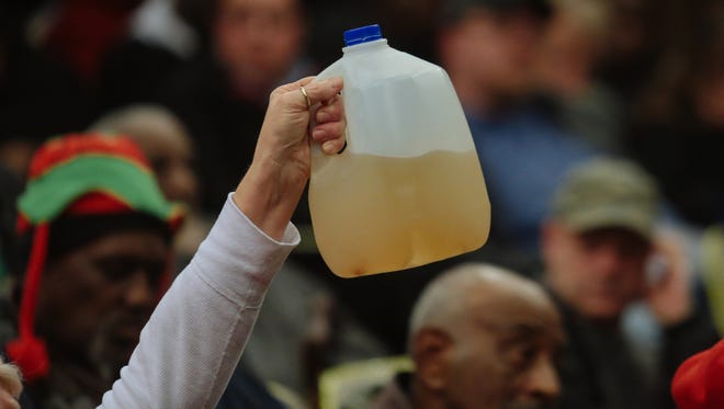 Flint, Mich., resident Gladyes Williamson-Bunnell holds a sample of water that came from her home she saved from August 2014.