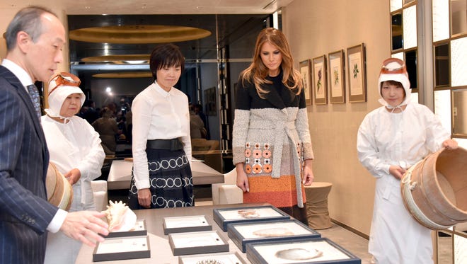 U.S. first lady Melania Trump and her Japanese counterpart Akie Abe, center, listens to sales manager Hajime Fukuju during their visit to Mikimoto Ginza Main Store, Japan's pearl jewelry maker, at Ginza shopping district in Tokyo Sunday, Nov. 5, 2017.
