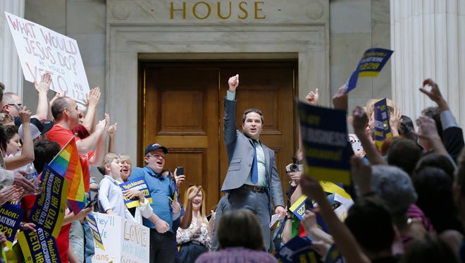 Rep. Warwick Sabin, D-Little Rock, center, cheers with protesters outside of the House chamber at the Arkansas state Capitol in Little Rock, Ark., Monday, March 30, 2015. A House committee earlier Monday advanced an amended version of a bill that opponents say allows discrimination against gays and lesbians. (AP Photo/Danny Johnston)