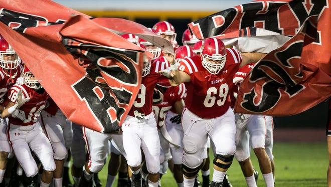 The Brophy Broncos run through a banner before the matchup between Brophy and Liberty, Friday, September 4, 2015, in Phoenix, Ariz.