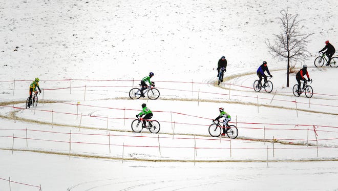 Competitors speed around the course during the junior boys and girls race during the annual Jingle Cross Cyclocross Race at the Johnson County Fairgrounds on Sunday, November 15, 2014.