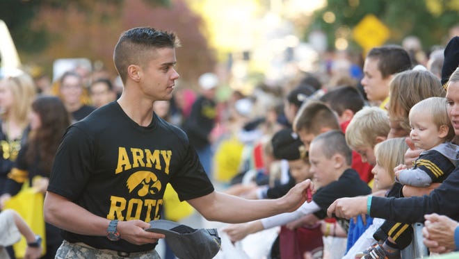 Scenes like this, of Lucas Roach of Des Moines handing out candy during last year's University Of Iowa Homecoming Parade, will take place Oct. 1 this year. The Hawkeyes will host Northwestern in this year's homecoming football game with an 11 a.m. kickoff, it was announced Tuesday.