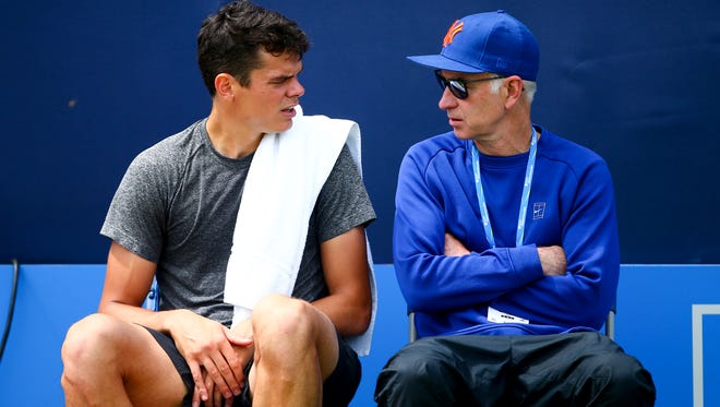 Canadian Milos Raonic, left, sits with his coach John McEnroe during a practice session last month at the Queens Club in London, England.