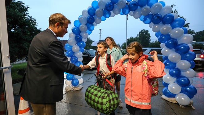Sacred Heart Model School Principal Michael Bratcher greets students as they arrive at school.  Wednesday was the first day of classes for many area schools including area Catholic schools.August 17, 2016