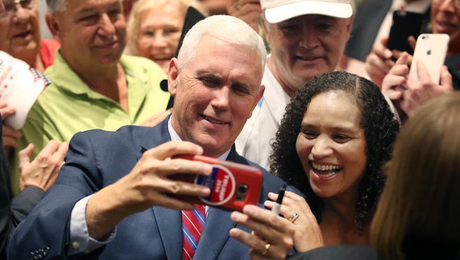 Republican vice presidential candidate Mike Pence takes a selfie photo with a supporter during a campaign rally at The Villages, Fla., on Sept. 17, 2016.