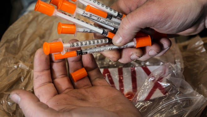 An intravenous drug user drops off used needles in an RV in the parking lot at Franklin County Health Department. Needle exchanges allow drug users to trade used needles for clean ones. Courier Journal file photo.