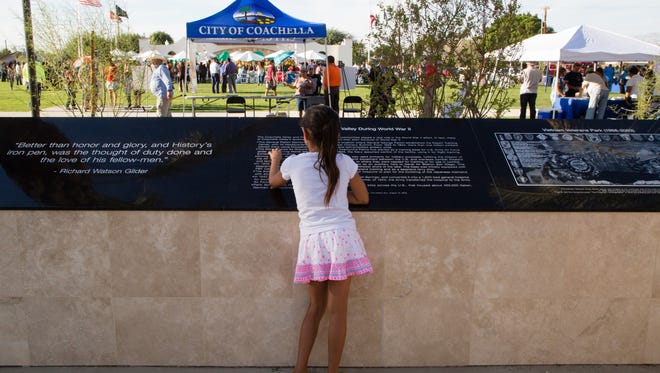 Olivia Castañeda, age 7, reads about the history of the Coachella Valley in World War II in Coachella's renovated Veteran's Memorial Park, Sunday, November 6, 2015.