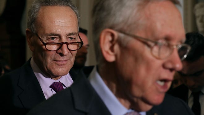 Sen. Charles Schumer (left), D-N.Y., listens to Senate Minority Leader Harry Reid talk to reporters earlier this year. Schumer is poised to take over Reid's leadership role in the Senate.