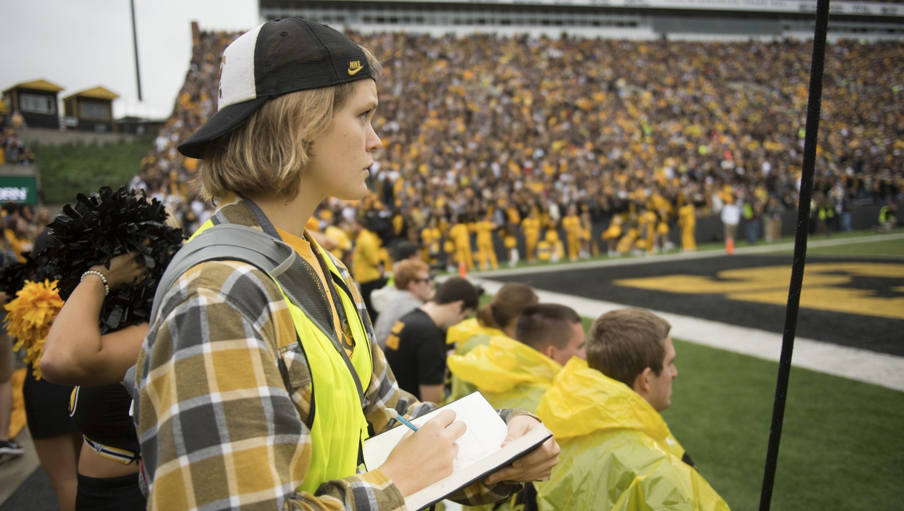 Elinor Krieger-Coble, a regent graduate in the UI School of Art and Art History, sketches from the sidelines of Kinnick Stadium during Iowa football games.