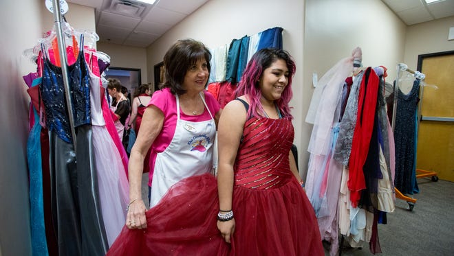 Patty Morris helps Reyna Aizu with a prom dress at the Cinderella Affair, in Chandler, Ariz., on March 25, 2017.