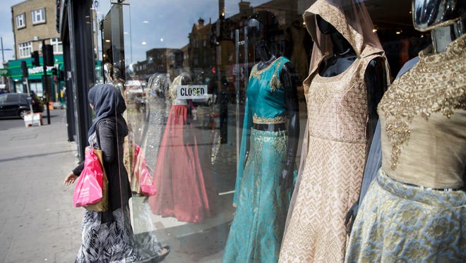 A person exits a shop at Upton Park, in London, Monday May 22, 2017. “Ten years ago, if you were a brand coming from a religious background and tried to sell it in department stores, calling it a modest or Muslim brand would be a kiss of death,” said Reina Lewis, a professor at the London College of Fashion who has written two books about the topic.