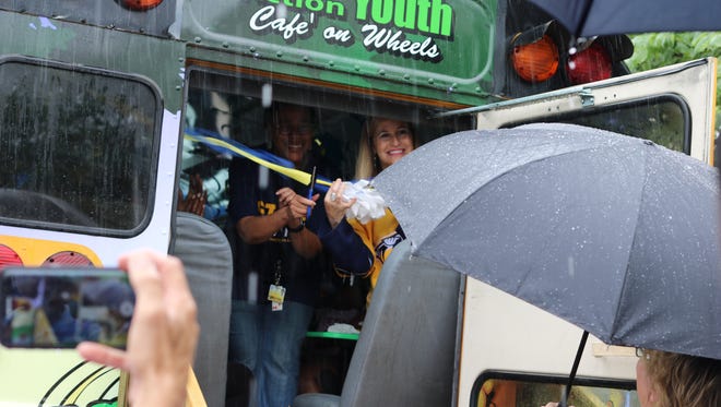 Nashville Mayor Megan Barry cuts the ribbon on a new Cafe on Wheels bus with Nashville Metro Action Commission Executive Director Cynthia Croom.