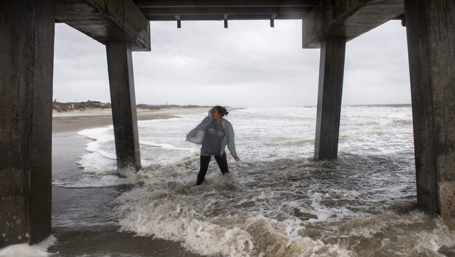 Madisen Norris reacts as waves begin to crash into her at Tybee Island on Sunday, Sept. 10, 2017. The area is beginning to see increased rain and wind as Hurricane Irma moves north toward Georgia. 
