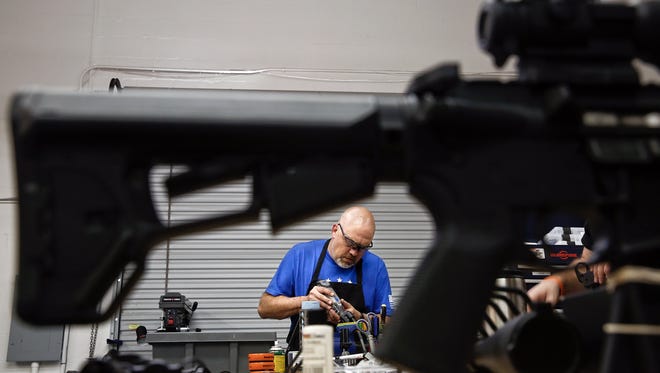 Jeff Coryell works on a rifle piece in the shop of his specialty firearms store and gunsmith shop, The Farm, in Naples on Friday, February 19, 2016.