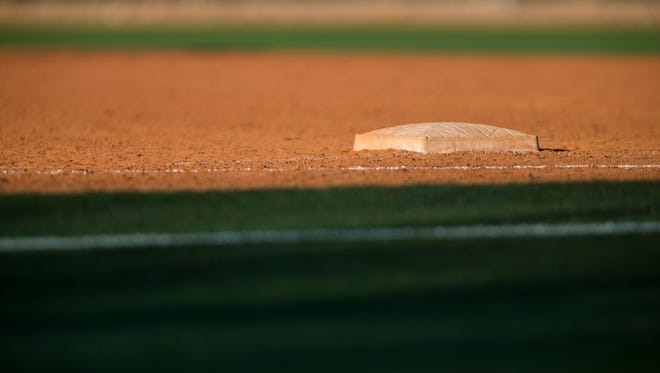 A base sits on a high school baseball field.