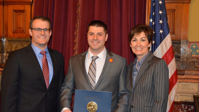 Gov. Kim Reynolds and Lt. Gov. Adam Gregg presented Matthew Walsh of Waukee, center, with the Benjamin F. Shambaugh Book Award for his book “The Good Governor: Robert Ray and the Indochinese Refugees of Iowa” during a ceremony April 11, at the Iowa Capitol.