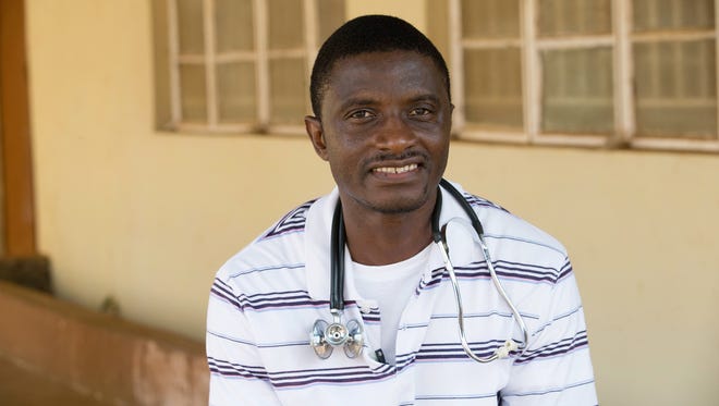 FILE - In this April 2014, file photo, provided by the United Methodist News Service, Dr. Martin Salia poses for a photo at the United Methodist Church's Kissy Hospital outside Freetown, Sierra Leone. Salia, who died of Ebola after treating patients in his native Sierra Leone, will be remembered in the suburbs of Washington, where his family lives. Forty-four-year-old Salia died earlier this month at the University of Nebraska Medical Center in Omaha. His body was cremated. A funeral Mass will be held Saturday, Nov. 29, at his family’s parish in Landover Hills, Md. Salia is survived by his wife and two sons. (AP Photo/United Methodist News Service, Mike DuBose, File) MANDATORY CREDIT